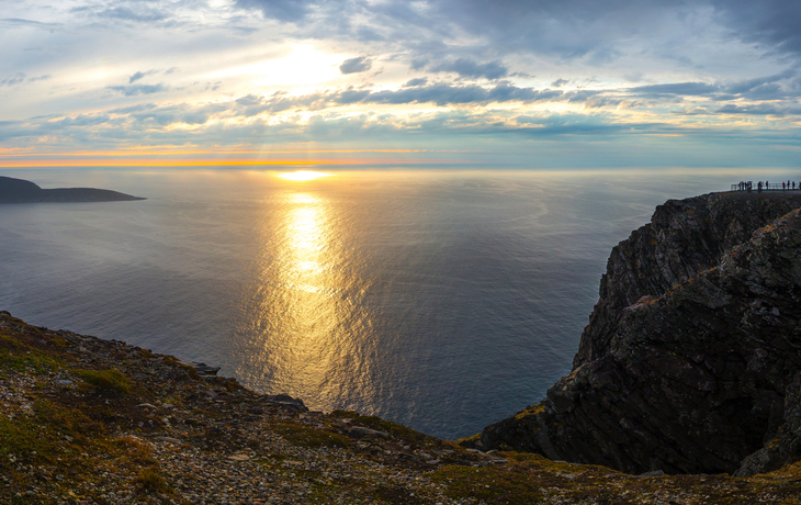 Aussichtspunkt mit Globus am Nordkap, Norwegen bei Mitternachtssonne über dem Meer.
