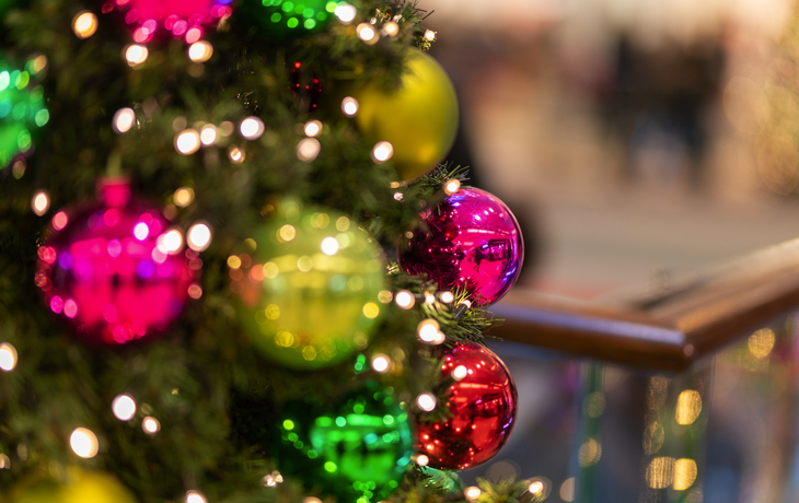 Geschmückter Weihnachtsbaum mit bunten Kugeln und Lichterkette.