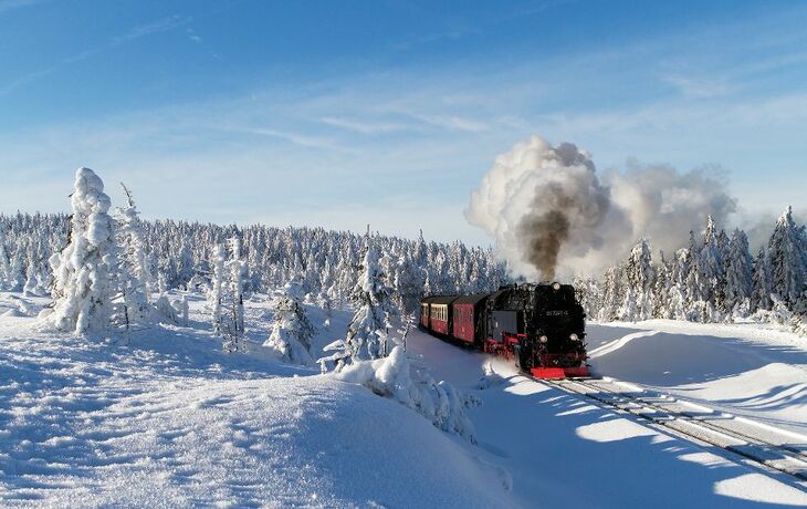 Dampflokomotive der Brockenbahn im schneebedeckten Winterwald im Harz.
