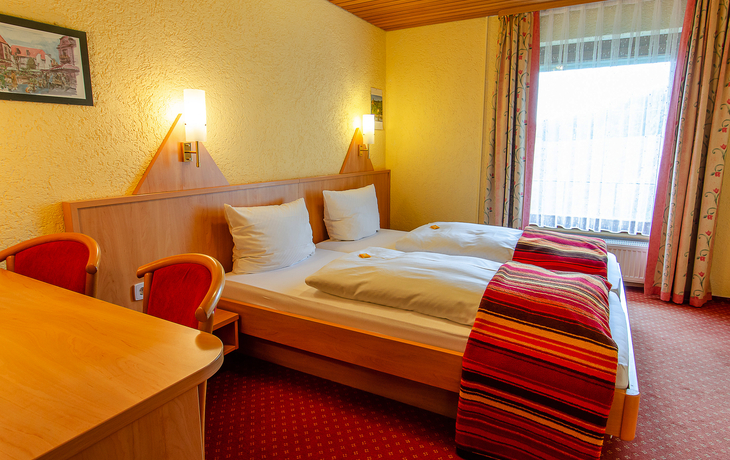 Hotelzimmer mit Doppelbett, Holzdekor und Tageslicht im Schwarzwaldhotel Roter Bühl
