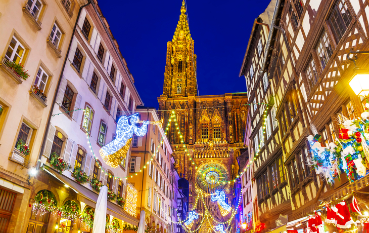 Beleuchteter Weihnachtsmarkt in Straßburg mit dekorierten Fachwerkhäusern.
