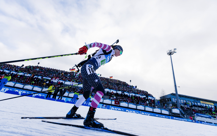 Biathlet im Rennen beim Biathlon-Weltcup in Oberhof, Publikum im Hintergrund.
