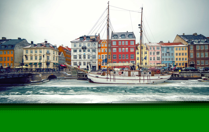 Nyhavn in Kopenhagen im Winter mit gefrorenem Hafen und bunten Gebäuden.