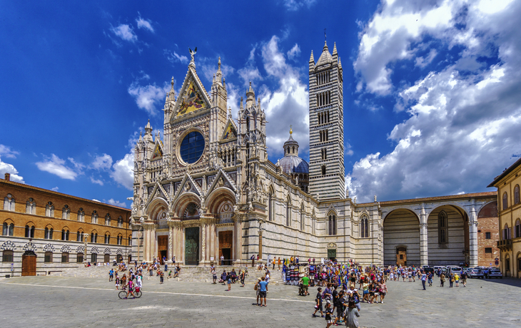 Dom zu Siena mit Menschen auf dem Platz bei sonnigem Himmel in Italien.