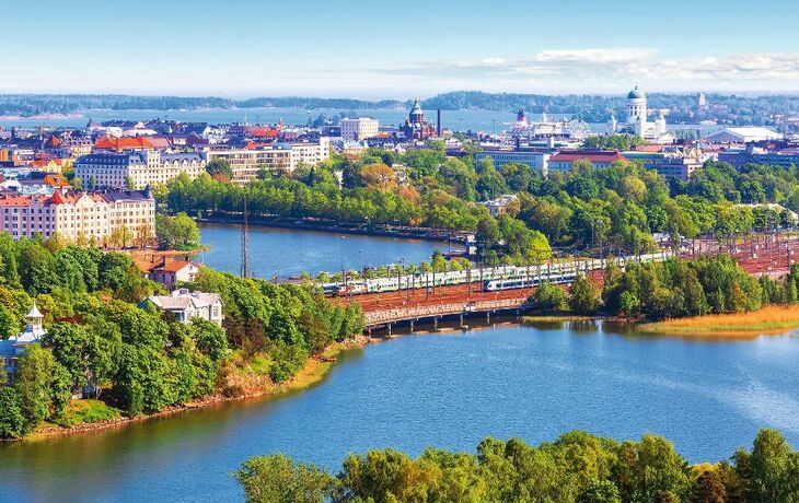 Panoramablick auf Helsinki mit Wasser und historischen Gebäuden im Hintergrund.