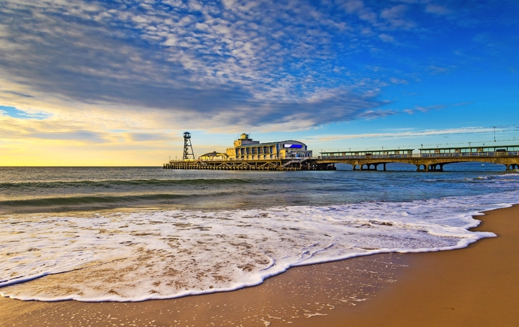 Bournemouth Pier bei Sonnenuntergang, Wellen am Sandstrand