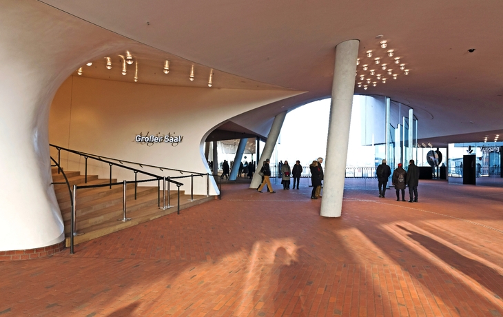 Innenansicht des Foyers der Elbphilharmonie in Hamburg mit Besuchern und architektonischen Details.