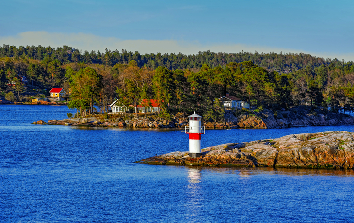 Ein Leuchtturm auf einer felsigen Insel im Stockholmer Schärengarten.