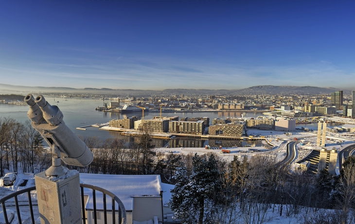 Oslo-Skyline im Winter mit Schnee und einem Fernglas im Vordergrund.