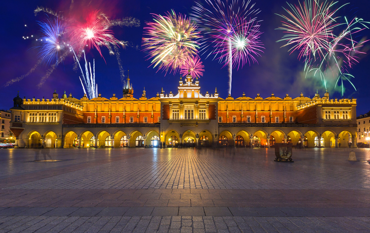 Feuerwerk über den Tuchhallen auf dem Hauptmarkt in Krakau bei Nacht.
