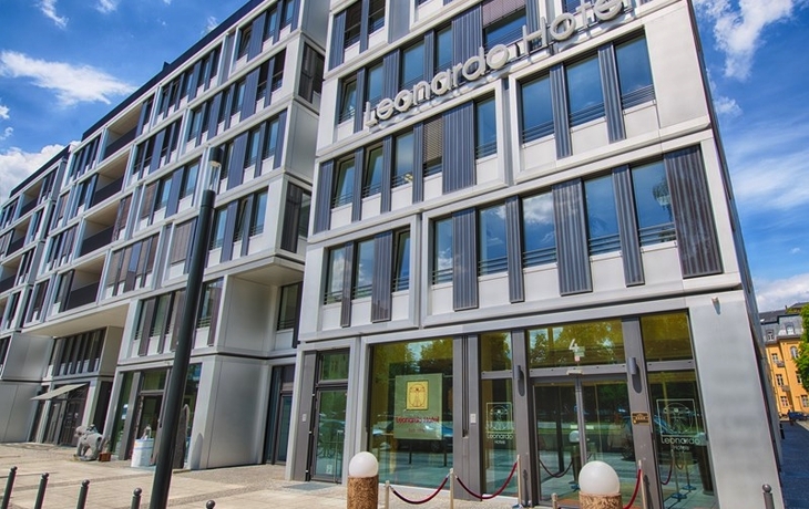 Eingangsbereich des Leonardo Hotels Berlin Mitte bei sonnigem Wetter.