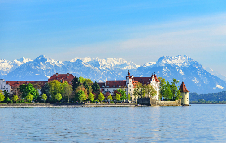 Inselstadt Lindau am Bodensee vor schneebedeckten Alpen im Frühling.