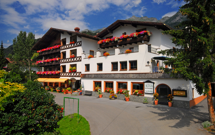 Hotel Alpina in Pettneu im Sommer mit Blumendekoration an Balkonen