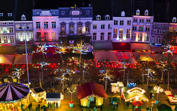 Weihnachtsmarkt auf dem Vrijthof in Maastricht bei Nacht mit festlicher Beleuchtung.