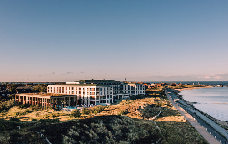 Hotelgebäude auf Sylt mit Sicht auf Meer und Dünen aus der Luftperspektive