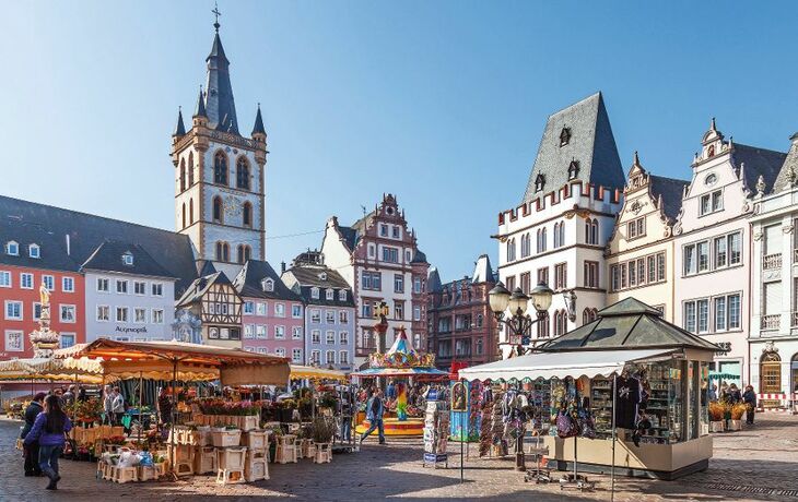 Historische Fachwerkhäuser und Marktstände auf dem Trierer Hauptmarkt.