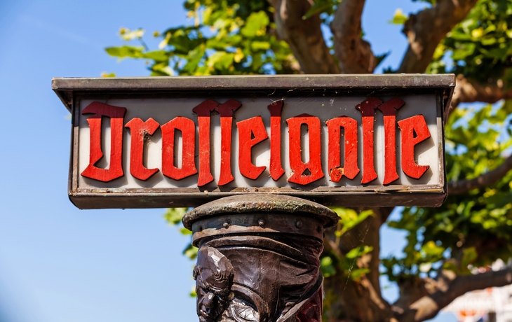 Schild der Drosselgasse in Rüdesheim am Rhein bei sonnigem Wetter.