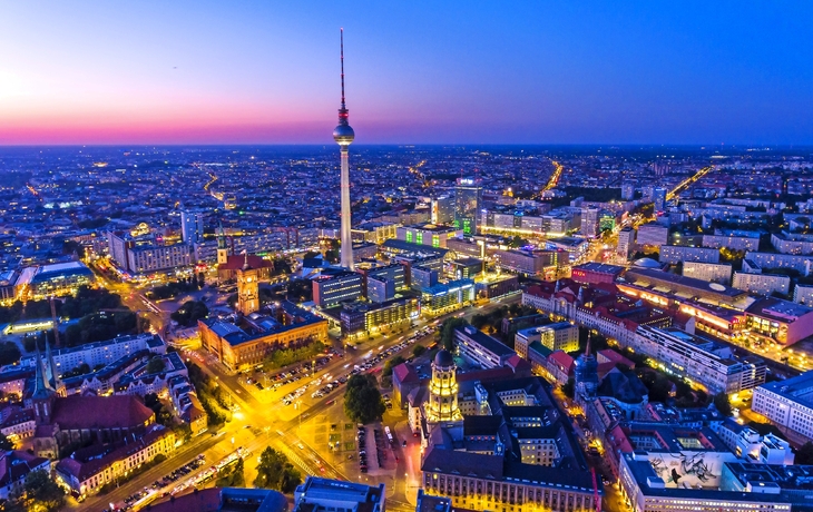 Skyline von Berlin bei Nacht mit Fernsehturm, Alexanderplatz und beleuchteter Stadt.