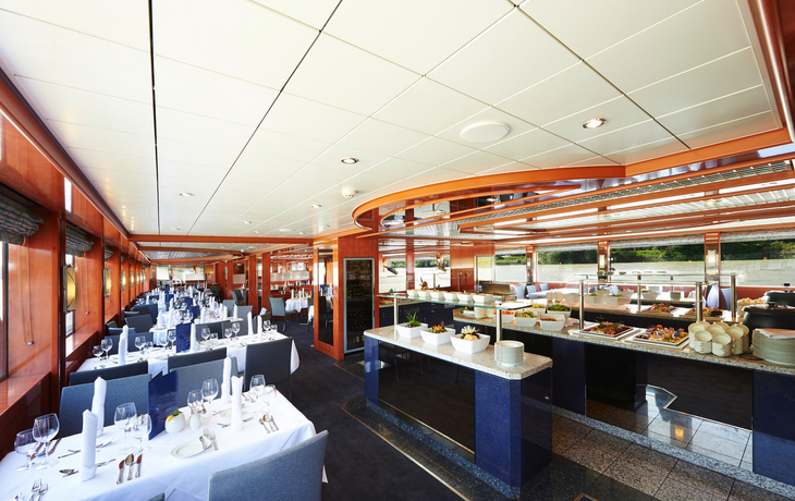 Elegantes Restaurant an Bord eines Schiffes mit gedeckten Tischen.