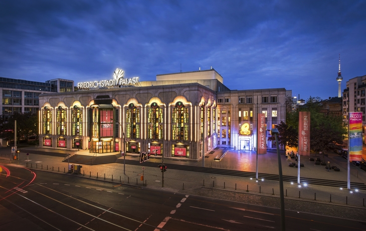 Außenansicht des Friedrichstadt-Palasts in Berlin bei Dämmerung.