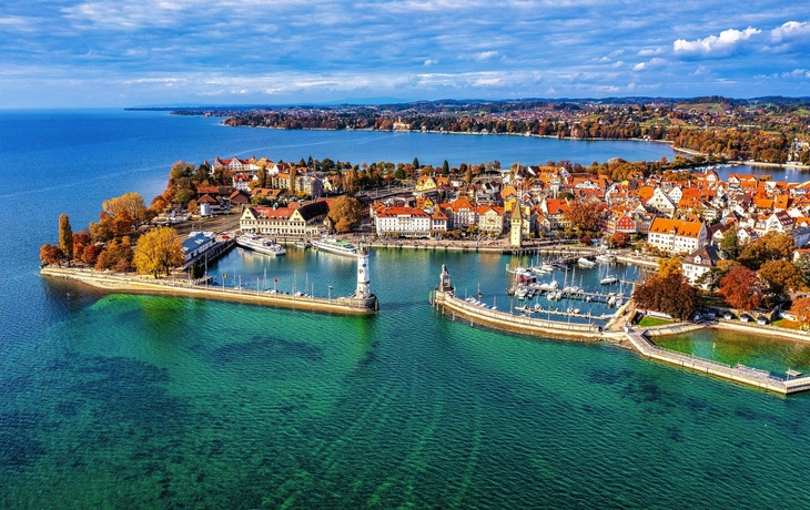 Hafen von Lindau am Bodensee mit Blick auf die Alpen im Hintergrund.