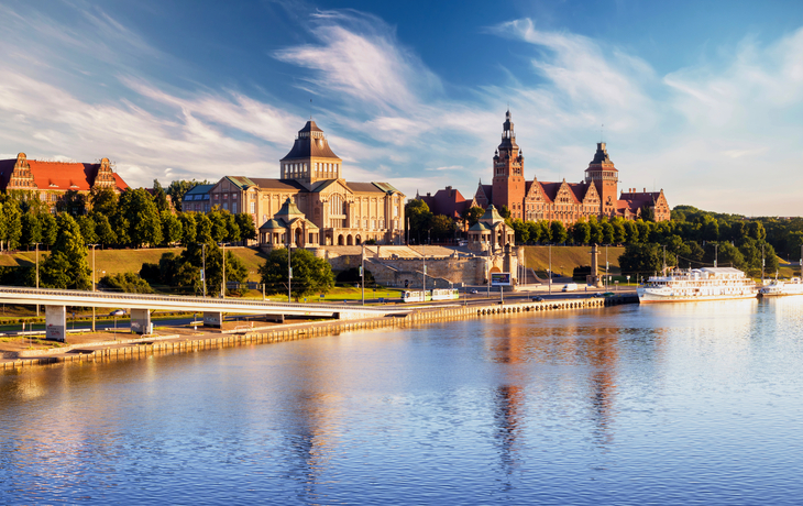 Historische Gebäude und Fluss bei sonnigem Himmel
