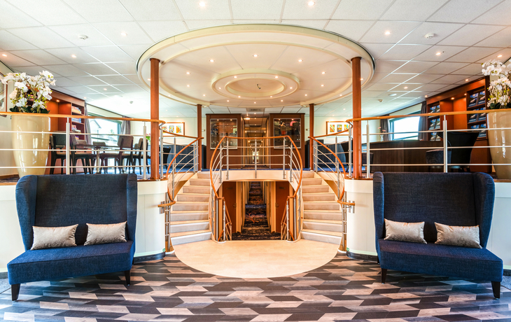 Rezeption mit moderner Innenausstattung und Treppe in der Mitte.