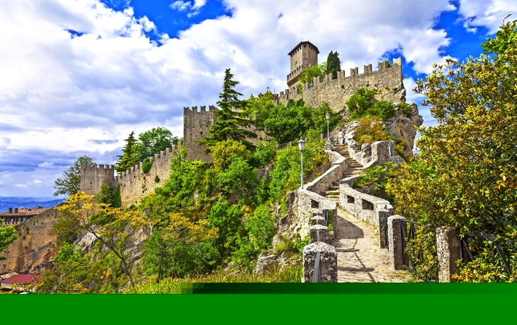 Mittelalterliche Burg auf einem Hügel mit steinernem Weg.