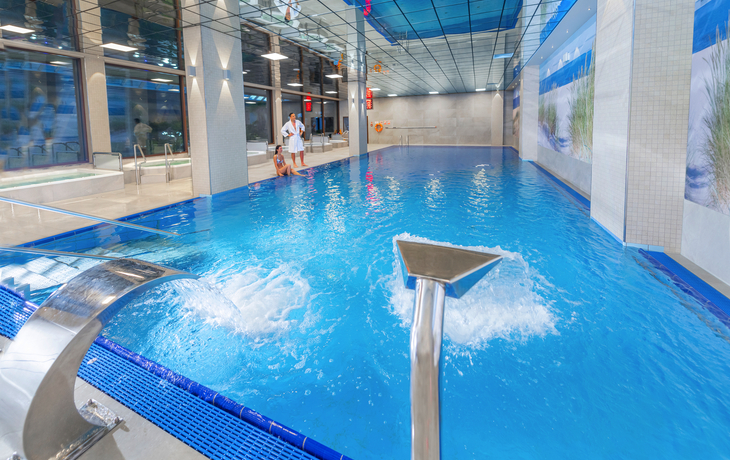 Innenansicht eines Schwimmbads mit Wasserfontänen im Hotel Olymp IV in Kolberg.