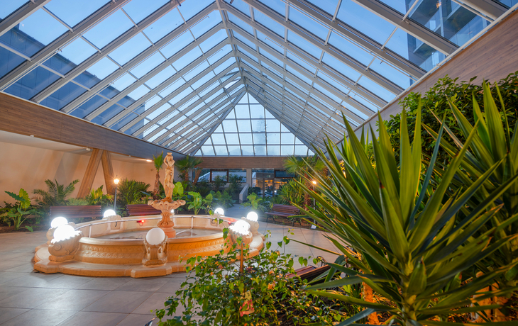 Orangeriegarten mit Glasdach und Brunnen im Hotel Olymp IV in Kolberg.