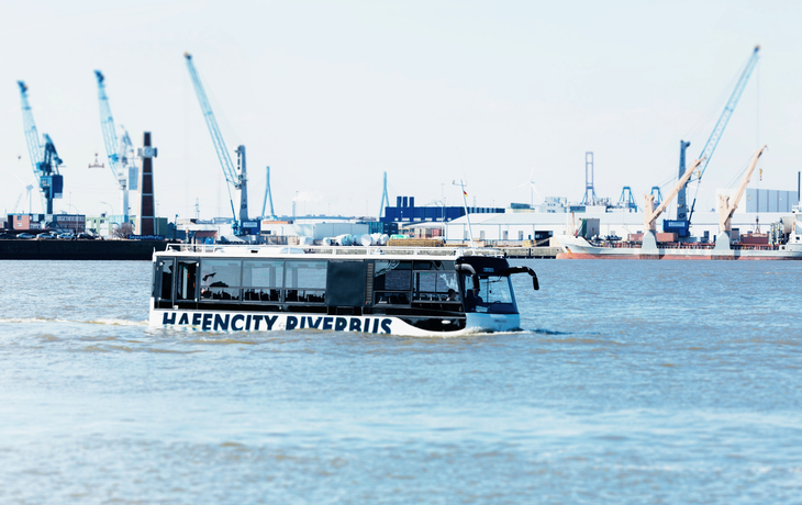 Amphibienbus auf dem Wasser vor Hafenkränen in der Hafencity.