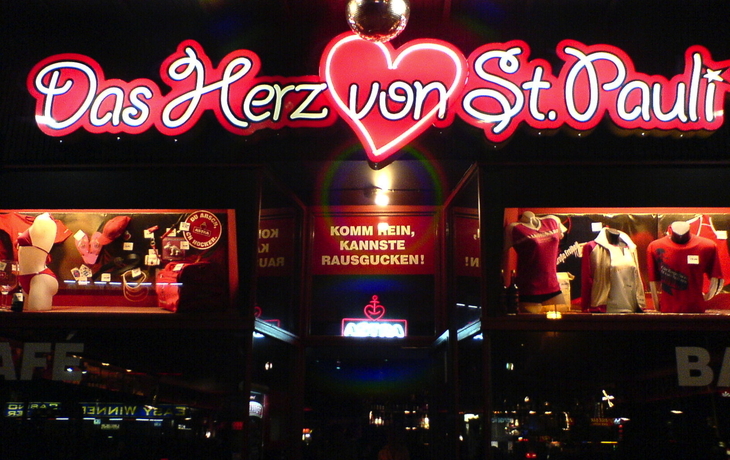 Leuchtendes Reklameschild und Schaufenster in der Nacht auf St. Pauli.