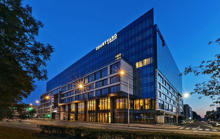 Außenansicht des Hotels Courtyard by Marriott Stettin bei Dämmerung.