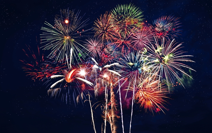 Ein buntes Feuerwerk erhellt den Nachthimmel mit verschiedenen Formen und Farben.