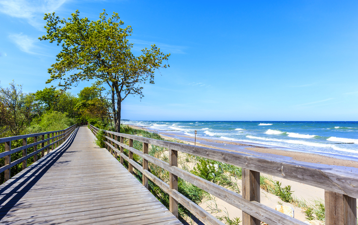 Holzsteg am Sandstrand von Kolberg, Ostsee, bei blauem Himmel