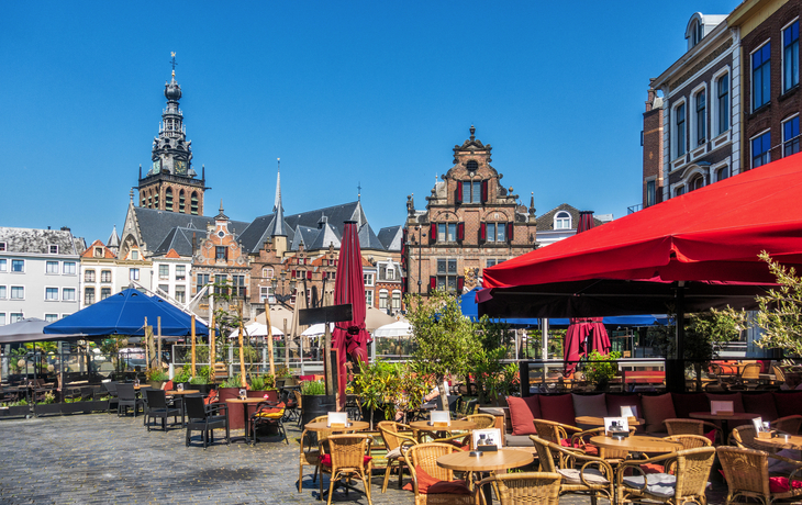 Stadtplatz mit Cafés und historischen Gebäuden unter klarem Himmel