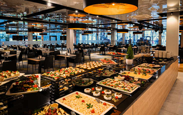 Ein Hotelrestaurant mit einem reichhaltigen Buffet und gedeckten Tischen.