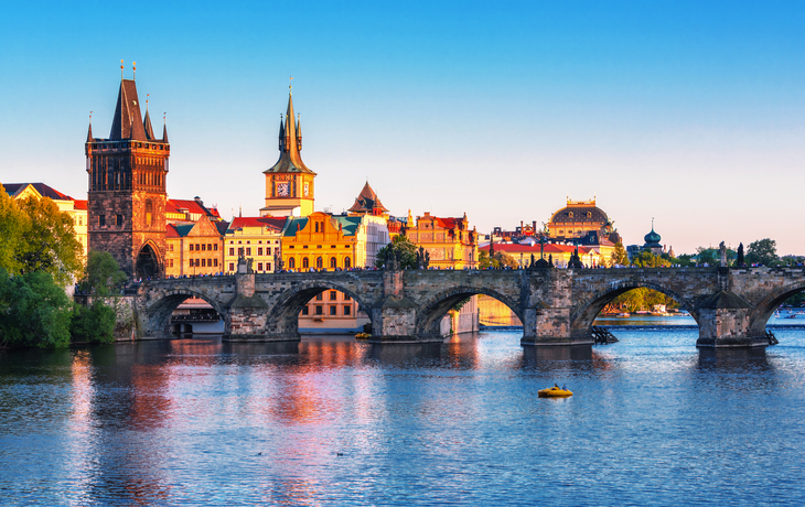 Karlsbrücke in Prag über die Moldau bei Tag, mit Skyline im Hintergrund.